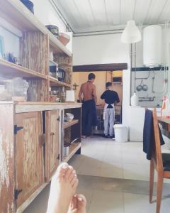 two men standing in a kitchen with their feet on the counter at Casa dos Corações - Turismo Regenerativo in Beirã
