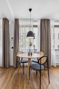 a dining room table with chairs and a lamp at limehome Oberhausen Paul-Reusch-Str in Oberhausen