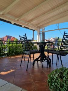 a patio with a table and chairs on a porch at Taverna 1860 Rooms & Apartments in Donja Zelina