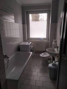 a bathroom with a tub and a toilet and a window at 5-Bett-Wohnung in Glöthe, Staßfurt in Staßfurt