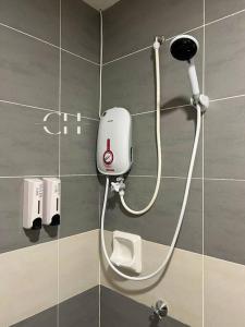 a shower in a bathroom with a hose on a wall at Kuching Apartment @ TT3 SOHO Near NorthBank in Kuching