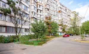 Un coche rojo aparcado delante de un edificio en Kvartirkoff na Obolonskiy prospekt 31, en Kiev