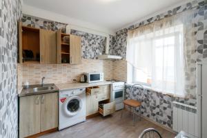 una cocina con lavadora y fregadero en Kvartirkoff na Obolonskiy prospekt 31, en Kiev 4 fotos más