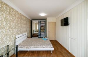 un dormitorio con una cama y un espejo en Kvartirkoff na Obolonskiy prospekt 31, en Kiev