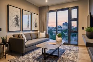 ein Wohnzimmer mit einem Sofa und einem Tisch in der Unterkunft The Catalyst Apartment Hotel by NEWMARK in Johannesburg