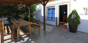 d'une terrasse avec une table en bois et un banc. dans l'établissement Casa Familiar 150 Metros de la Playa El Palmar, à El Palmar