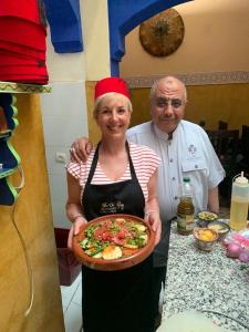 a man and a woman holding a plate of food at Riad Green Vines in Marrakesh