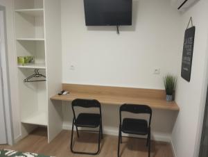 dwa krzesła siedzące przy biurku w pokoju w obiekcie ALBICASA appart hotel w mieście Albi