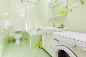 a white bathroom with a sink and a washing machine at Amigo Comfort Apartments in Split