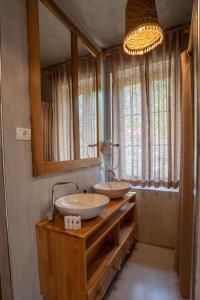 a bathroom with two sinks and a large mirror at Hotel Restaurant Alpet Theth in Theth