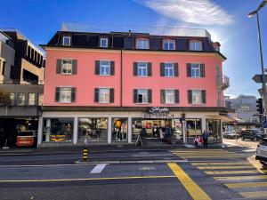 a large pink building on a city street at SCHNYDER'S HOME - Studio_1 in Rapperswil-Jona