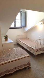 フィナーレ・リーグレにあるMansarda Cavassolaのベッド2台と窓が備わる客室です。