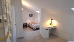 フィナーレ・リーグレにあるMansarda Cavassolaのベッドルーム1室(ベッド1台、ランプ付きデスク付)