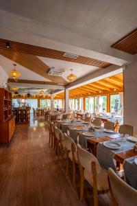 a dining room with wooden tables and chairs at Hotel Restaurant Alpet Theth in Theth