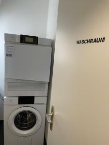Waschmaschine und Trockner in einem Zimmer mit Tür in der Unterkunft SCHNYDER'S HOME - Studio_1 in Rapperswil-Jona