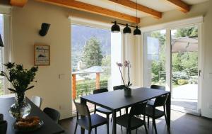 uma sala de jantar com mesa e cadeiras e uma grande janela em La Maison du Renard, villa con giardino e vista sulle montagne em Aosta