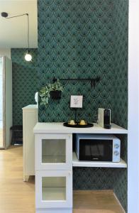 - une cuisine avec un four micro-ondes et un mur vert dans l'établissement Studio no5 Green, à Sighişoara