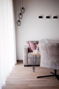 uma sala de estar com um sofá e uma mesa em Alpenstolz Damüls Haus 4 - Stilvoll urlauben in den Bergen em Damüls