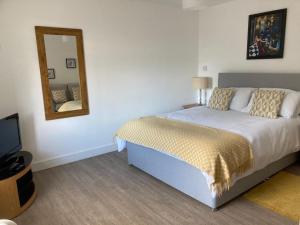 een slaapkamer met een bed en een spiegel aan de muur bij Aberlour Apartment 92 B in Aberlour