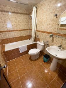 a bathroom with a toilet and a sink and a tub at Little Brick Saigon Hotel in Ho Chi Minh City