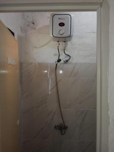 a shower in a bathroom with a camera on the wall at Rumah Pantai Krui in Wainapal