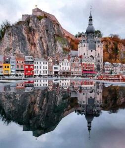 une ville avec sa réflexion dans l'eau dans l'établissement Appartement Luna, à Dinant