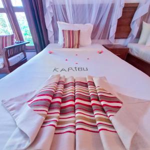 a white bed with a karlin blanket on it at Zanzibar Bahari Villas in Matemwe