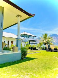 a view of a house with a grass yard at Batur Volcano Guesthouse in Kintamani