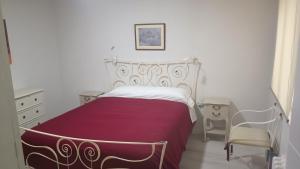a white bedroom with a bed and a chair at The Flats in Ávila