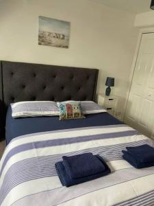 a bedroom with a bed with blue towels on it at Honey Cottage in Totland