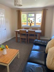 a living room with a couch and a table at Honey Cottage in Totland