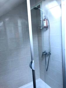 y baño con ducha con cabezal de ducha. en Chambre double avec salle de bain privative en Auxerre