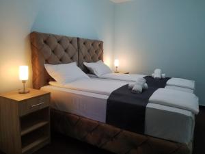 una camera da letto con un letto grande con una grande testiera di Vila Dvor SUBOTICA a Subotica