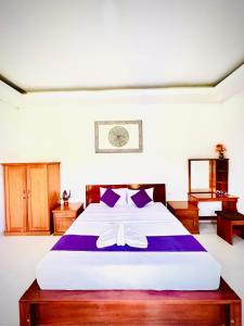 a bedroom with a large bed with purple sheets at Batur Volcano Guesthouse in Kintamani