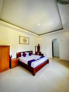 a bedroom with a large bed with purple pillows at Batur Volcano Guesthouse in Kintamani