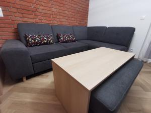 a living room with a couch and a table at Apartament na Irysowej in Dobrzeń Wielki