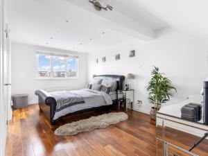 a white bedroom with a bed and a window at Willow Road Enfield Town Greater London in Enfield