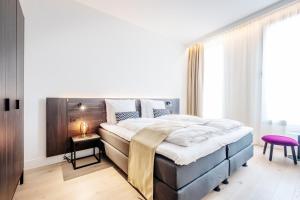 トゥルンハウトにあるCorsendonk Turnovaのベッドルーム1室(大型ベッド1台、木製ヘッドボード付)