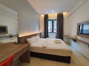 a hotel room with a bed and a television at Hotel Golden View Nilai in Nilai