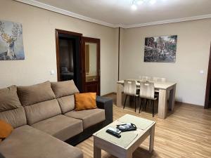 ein Wohnzimmer mit einem Sofa und einem Tisch in der Unterkunft Piso La Reina in Medina del Campo