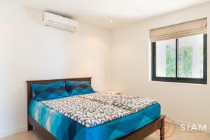a bedroom with a blue bed and a window at Chaweng Hill 2Br in Koh Samui