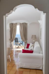 a living room with a white couch and a view of the ocean at Hotel Marincanto in Positano