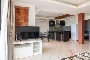 a living room with a tv and a kitchen at Chaweng Hill 2Br in Koh Samui