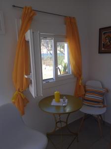 ein Raum mit einem Tisch und einem Fenster mit einer Kerze in der Unterkunft Studios Melusine in Limenas Thasou + 18 Fotos