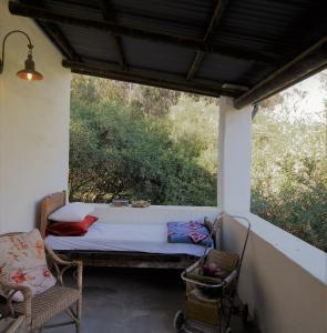 um quarto com uma cama e uma cadeira num alpendre em The Little Farmhouse em Stanford