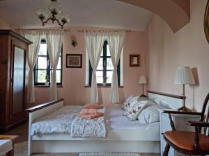 a bedroom with two beds and two windows at Taverna 1860 Rooms & Apartments in Donja Zelina