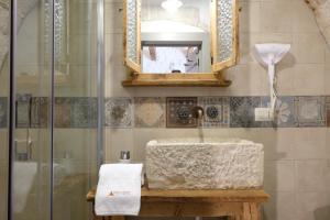 a bathroom with a sink and a shower with a mirror at Trulli Soave in Alberobello