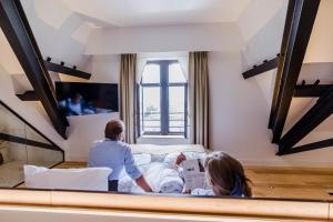 um grupo de pessoas sentadas numa cama num quarto em Corsendonk Turnova em Turnhout