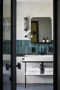 Ultimate Provence Hotel & Spa في لا غارد-فرينيه: حمام مع حوض ومرآة ومناشف