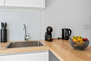 a kitchen with a sink and a bowl of fruit at Apartment Sunshine Cres in Cres